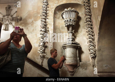 Touristen fotografieren die Dekoration von menschlichen Knochen und Schädel in Sedlec Ossuary in Kutna Hora, Tschechien. Stockfoto