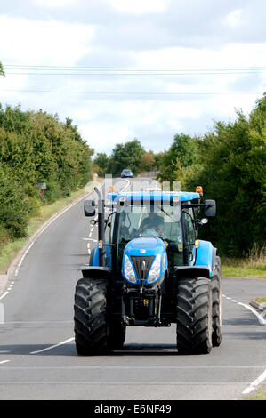 New Holland Traktor unterwegs Fosse Way, Warwickshire, UK Stockfoto