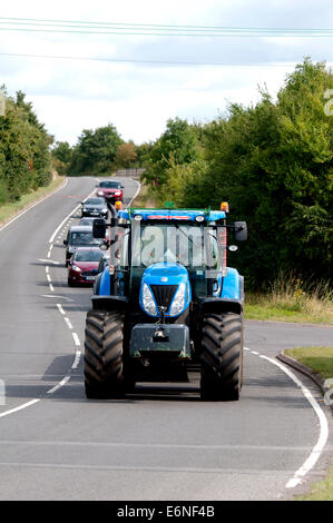 New Holland Traktor unterwegs Fosse Way, Warwickshire, UK Stockfoto