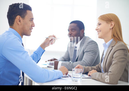 Gruppe von zuversichtlich Geschäftspartner Interaktion zu Sitzung im Büro Stockfoto