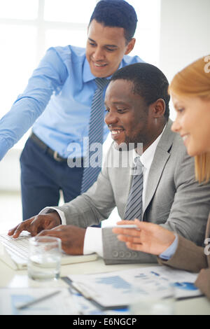 Gruppe von zuversichtlich Mitarbeitern diskutieren Computerprojekt Stockfoto