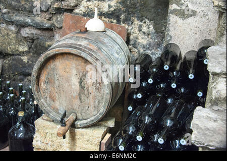 Alten Weinfässern und Flaschen im Keller Stockfoto