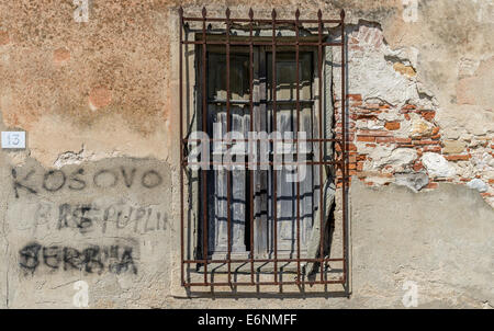 Hölzerne Fensterläden durch Metall Fenstergitter geschützt. Stockfoto
