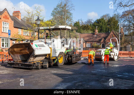 Straßenarbeiten. Fertiger, Straßenwalze und Beschäftigten im Straßenverkehr während der Straße resurfacing Arbeiten an einem Dorf Straße, Nottinghamshire, England, Großbritannien Stockfoto