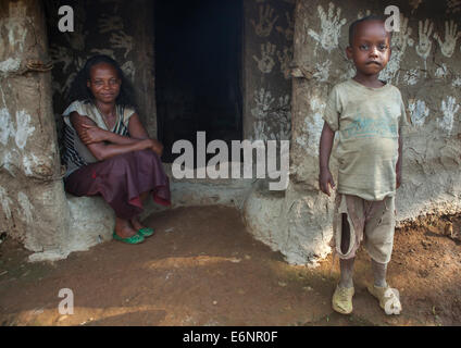 Frau und ihr Sohn vor ihrem traditionellen Haus verziert mit Handabdrücke bringen Glück, Tepi, Äthiopien Stockfoto