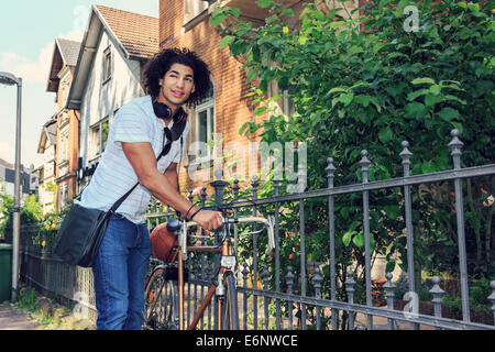 Porträt des jungen männlichen Studenten mit dem Fahrrad in die Stadt Stockfoto