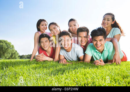 Gruppenfoto der fröhliche junge Erwachsene auf dem Rasen liegend Stockfoto