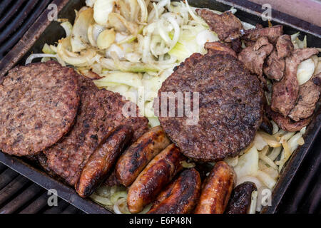 Grillplatte von Beef Burger, Würstchen, Speck und Zwiebeln. Stockfoto