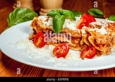 Italienische Lasagne mit Tomaten und Gemüse und Käse auf Holztisch Stockfoto