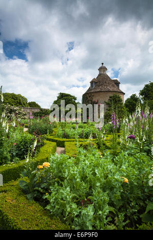 Das Feld abgesichert Parterre mit Sommerblumen und c.1685 Taubenschlag im ummauerten Garten der Rousham House, Oxfordshire, England Stockfoto