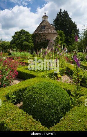 Das Feld abgesichert Parterre mit Sommerblumen und c.1685 Taubenschlag im ummauerten Garten der Rousham House, Oxfordshire, England Stockfoto