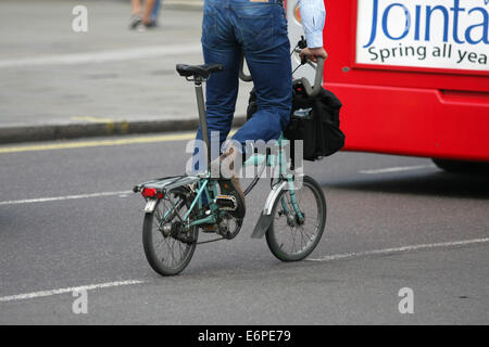 Ein Radfahrer und Bus Reisen entlang einer Straße in London Stockfoto