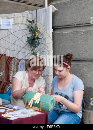 Frau unterrichtet traditionelle Klöppeln, ein junges Mädchen das Festival of Folk Arts in Budapest, Ungarn Stockfoto