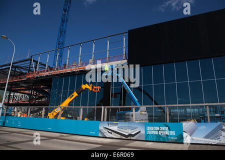 ACC Liverpool Dockland Waterfront, Merseyside, Bauarbeiten an der Fassade des neuen Kings Dock Exhibition Centre sind im Gange. Die Außenverkleidung wird mit einem Vakuumheber „Clad Boy“ befestigt (mit Klebeband versehen), der mit zwei Arbeitern am JCB-Kran 540 170 befestigt ist, wobei die Verkleidungseinheiten mit der Verlängerungsschaufel „EASI-Lifts“ befestigt werden. Liverpool in Work unterstützt den Hauptauftragnehmer für die Entwicklung, ISG Construction, mit Zugang zu den lokalen Arbeits- und Subunternehmern sowie Unterstützung bei der Besetzung von offenen Stellen und Lehrstellen. Stockfoto