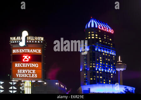 Bunt beleuchtete Gebäude des Niagara Fallsview Casino Resort in der Nacht. Ortseingangsschild zeigt Temperatur in Grad Celsius. Stockfoto