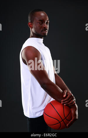 Junge afrikanische amerikanische Basketballspieler auf schwarzem Hintergrund Stockfoto