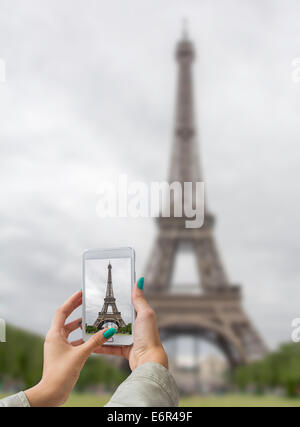 Junges Mädchen Reisen und Bilder Eiffelturm, mit Handy Stockfoto