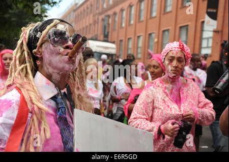 Frauen in Nottinghill Carnival am Familientag, raucht eine Zigarre Stockfoto