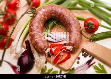 Rohwurst mit Gemüse auf Holzbrett, selektiven Fokus Stockfoto