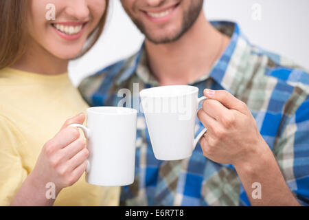 Lächelnde paar halten zwei Tassen Kaffee Stockfoto