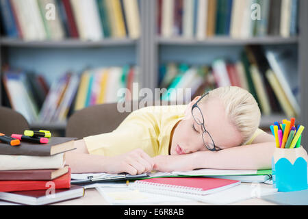 Müde Schüler mit Brille schlafen in Bibliothek Stockfoto