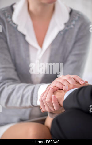 Nahaufnahme der Psychiater halten ihre Hände zusammen mit ihrer Patientin Stockfoto