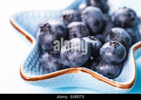 Heidelbeeren hautnah in einer blauen Schüssel Stockfoto