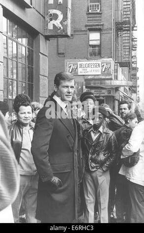 4. November 1960 - Harlem, New York, USA - Sir Roger George Moore, KBE (geboren 14. Oktober 1927) ist ein englischer Schauspieler. Er ist vielleicht am besten bekannt für die Wiedergabe von britischen Geheimagenten James Bond in der offiziellen Filmserie für sieben Filme von 1973 bis 1985. Er trat als Bond in offizielleren Bond-Filmen als jeder andere Schauspieler, und ist der älteste Schauspieler Bond zu spielen. Moore spielte Simon Templar in The Saint von 1962 bis 1969. Er ist auch eine Goodwill-Botschafter für die Hilfsorganisation UNICEF. Bild: ROGER MOORE von seiner Frau Luisa fotografiert, während Harlem Zuschauer in der Nähe ein Feinkostgeschäft aussehen, auf Stockfoto