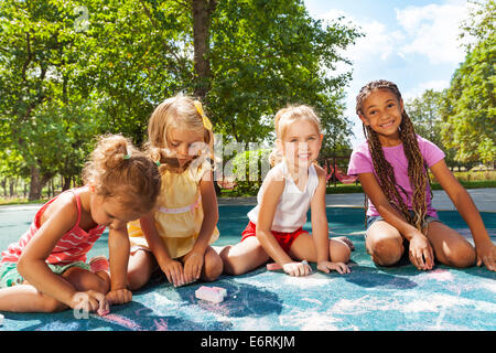 Mädchen zeichnen auf Spielplatz Bild mit Kreide Stockfoto