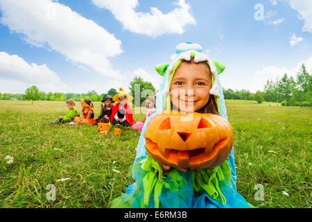 Niedliche Mädchen in Monster Kostüm hält Kürbis Stockfoto