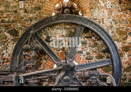 Ein Eisenrad hängt auf den Ruinen einer alten Zuckerplantage in der Karibik Stockfoto