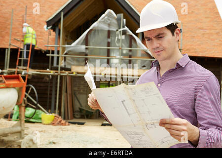 Architekten auf der Baustelle betrachten Hauspläne Stockfoto