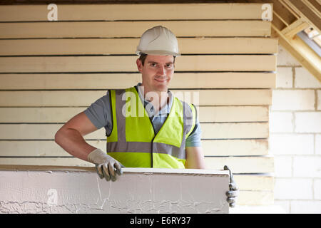 Baumeister, die Montage von Dämmplatten bis zum Dach des neuen Hauses Stockfoto