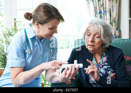 Krankenschwester Beratung Senior Woman auf Medikamente zu Hause Stockfoto