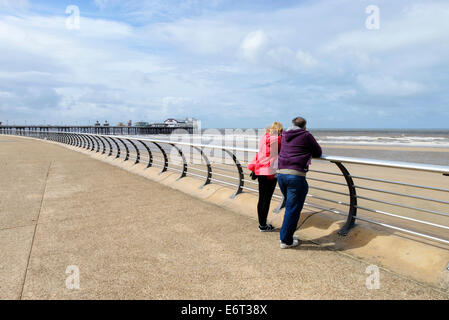 Paar mittleren Alters an der Promenade von Blackpool. North Pier ist im Hintergrund Stockfoto