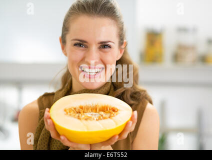 Glückliche junge Frau zeigt Melone slice Stockfoto
