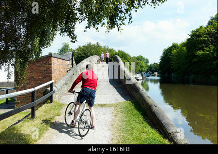 Radfahrer Überqueren der Kanalbrücke bei Burscough Stockfoto