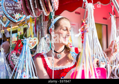 Frau Wahl Lebkuchenherz auf dem Oktoberfest Dirndl tragen Stockfoto