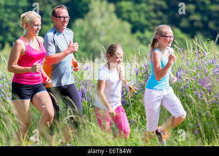 Familie, die für mehr Fitness im Sommer durch wunderschöne Landschaft Stockfoto