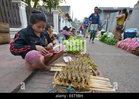 Luang Prabang, Laos - 1. März 2014: Frau verkauft Lebensmittel auf dem Markt in Luang Prabang, Laos. Stockfoto