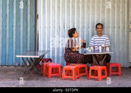 Erwachsenen Vietnamesisch Paar, Kaffeetrinken in den frühen Morgenstunden, in einer kleinen Straße Café in Hanoi, Vietnam. Stockfoto