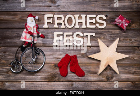 Frohe Weihnachten Text auf Holz mit rustikalen lustige rote Dekoration mit dem Weihnachtsmann auf Holz. Stockfoto