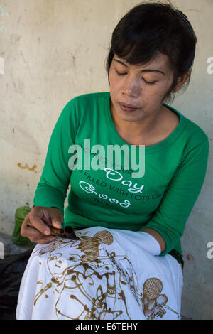 Yogyakarta, Java, Indonesien.  Batik-Produktion.  Frau mit heißem Wachs, eine Design auf eine Batik Tuch zu skizzieren. Stockfoto