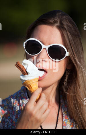 Eine junge Frau, Essen ein Eis im Hyde Park im Sommer Stockfoto