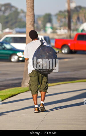 Man sammelt leere Dosen aus Edelstahl Mülleimer In Long Beach, Kalifornien. Stockfoto