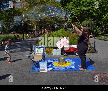 Frau im Washington Square Park in New York City große Seifenblasen und unterhalten Kinder.