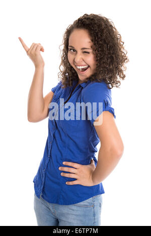 Verrückte junge Mädchen in blau, die etwas mit ihrem Zeigefinger über weißem Hintergrund zeigt. Stockfoto