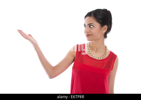 Lächelnde indische Frau in rot präsentieren mit ihrer Hand über weißen Hintergrund isoliert. Stockfoto