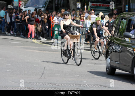 Zwei Radfahrer Reiten in London hinter ein Taxi, eine Signalisierung nach links abbiegen Stockfoto