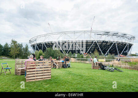Stratford, London, UK, 30. August 2014.  Der Bürgermeister von London Liberty Festival, Teil des nationalen Paralympischen Tag 2014 bei der Queen Elizabeth Olympic Park präsentiert Behinderung Kunst und integrativen Sport.  Im Bild: Menschen Picknick gegenüber das Olympiastadion, die derzeit saniert, ist.  Bildnachweis: Stephen Chung/Alamy Live-Nachrichten Stockfoto